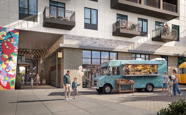 A blue food truck is parked outside a modern building, with two people standing nearby on the sidewalk.